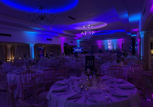 dark display of a venue room with round tables and chairs set up