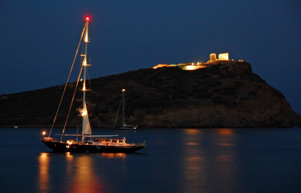 distant photo of sounion temple from the sea and a boat 