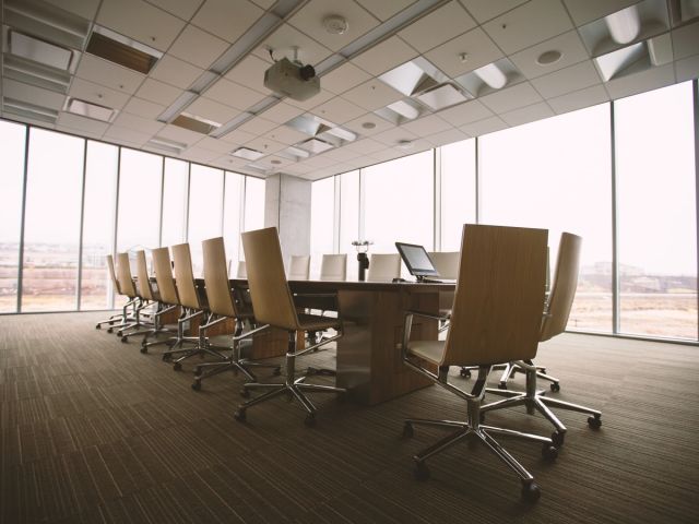photo of conference room with glass windows wooden floor and brown chairs