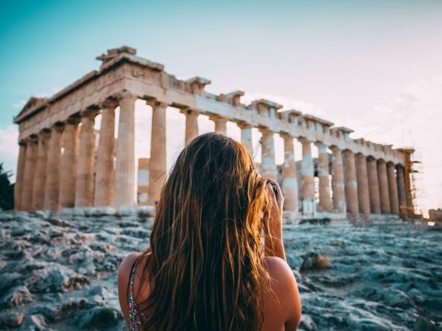 photo of a back of a girl getting a photo of accropolis